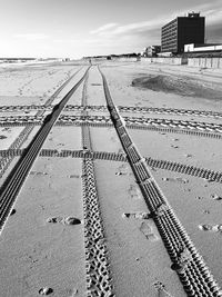 Tire tracks on railroad track against sky