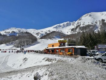 Building on snowcapped mountain against sky