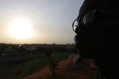 Portrait of man wearing sunglasses against sky during sunset