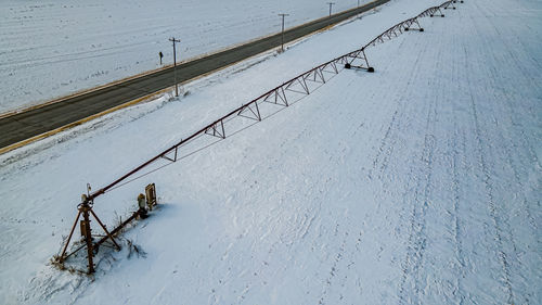 Off season snow covered farm field with rural road