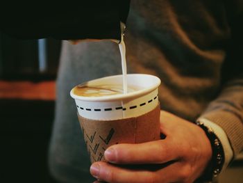 Cropped image of man pouring coffee in disposable cup