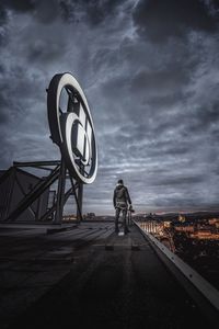 Rear view of man standing on road against sky