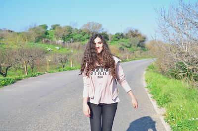 Portrait of young woman standing on road