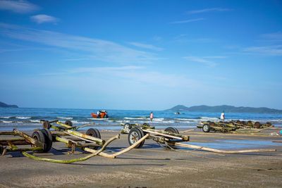 Carts at beach against blue sky