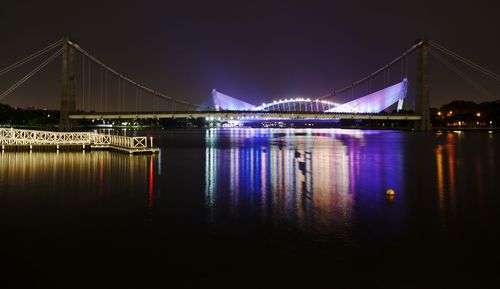 View of suspension bridge over river at night