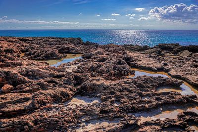 Rocks on beach against sky