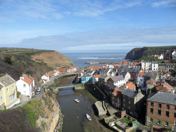 High angle view of townscape by sea against sky