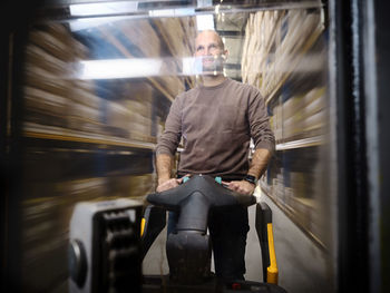 Warehouse worker pushing hand truck in alley