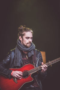 Fashionable musician playing guitar