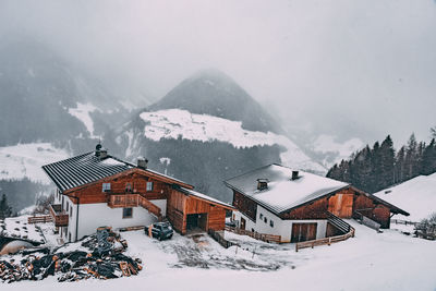 Houses on snow covered mountain against sky