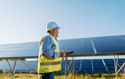 Senior male engineer with digital tablet contemplating in solar field