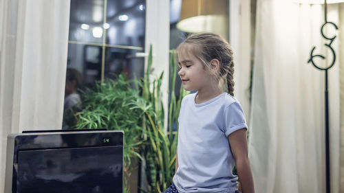 Smiling woman standing by dehumidifier at home