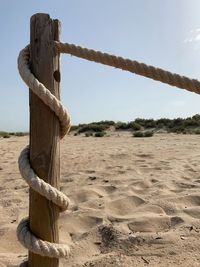 Wooden post on field against sky