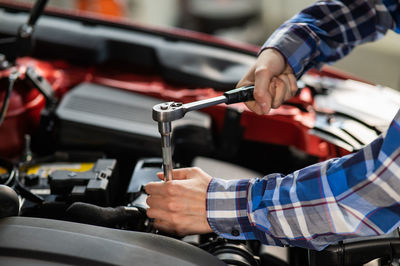 Cropped hand of man repairing vehicle