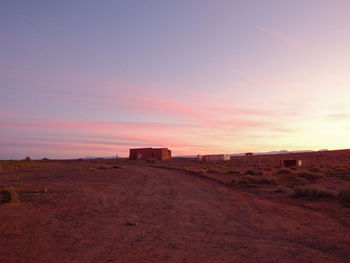 Built structure on field against sky during sunset