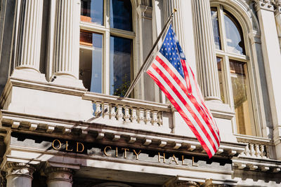 Low angle view of flag against buildings in city