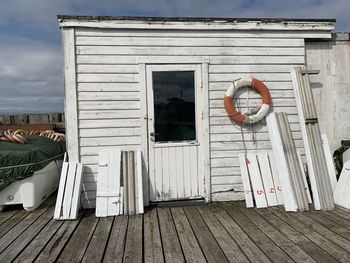 Exterior of white wooden boat house, closed door and wooden material 