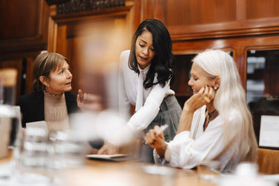 Female lawyer discussing with colleagues in meeting at office