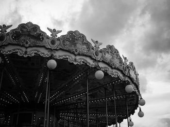 Low angle view of chain swing ride against sky