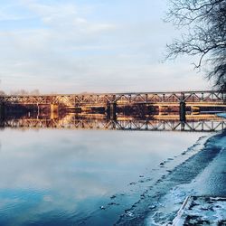 Bridge over snow covered landscape against sky