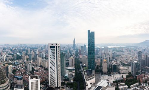 Aerial view of buildings in city against sky