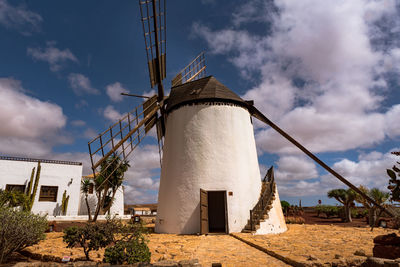 Low angle view of traditional windmill against sky