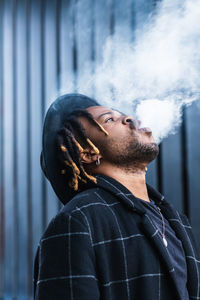 Portrait of young man smoking outdoors