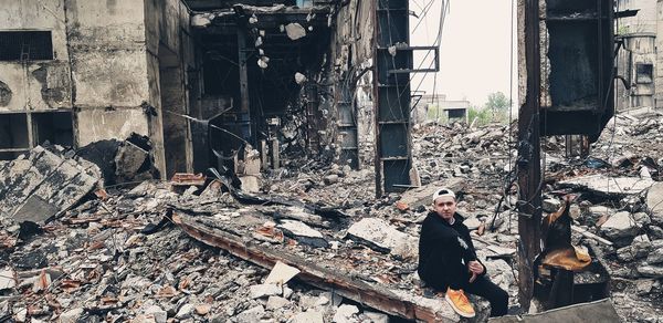Woman sitting on old abandoned building