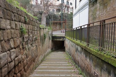 Empty footpath amidst buildings