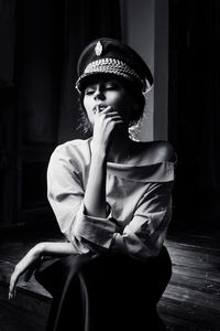 Portrait of young woman wearing military hat