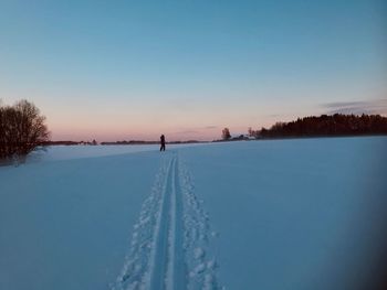 Scenic view of snow covered field against clear blue sky