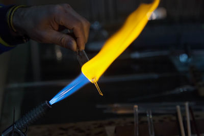 Close-up of hands making glass in factory