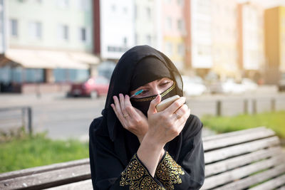 Young woman using mobile phone in city