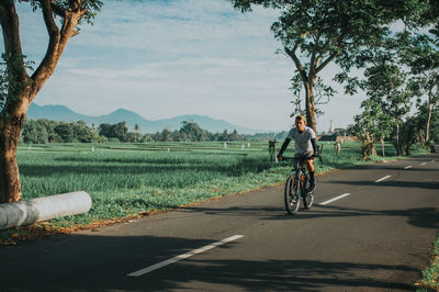 Man riding bicycle on road