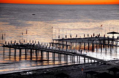 Pier on sea at sunset