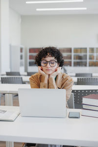 Young woman using laptop at table