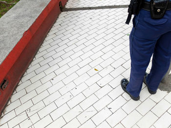 Low section of man standing on tiled floor