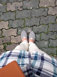 Low section of woman standing on footpath