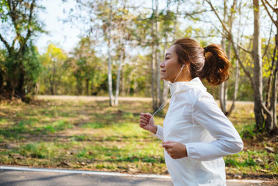 Smiling woman jogging on road