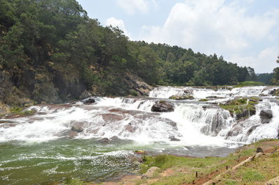 Scenic view of waterfall against sky