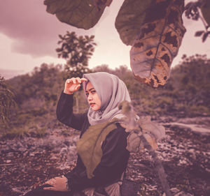 Portrait of woman sitting on rock in the nature