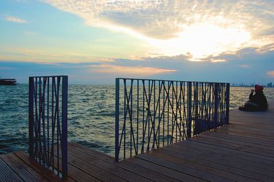 Pier on sea at sunset