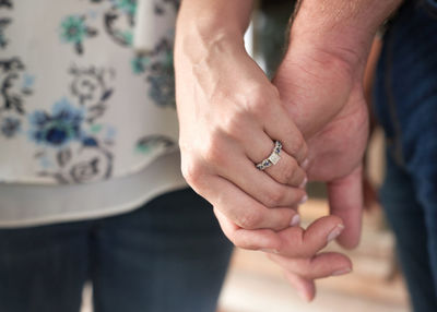 Midsection of couple holding hand outdoors