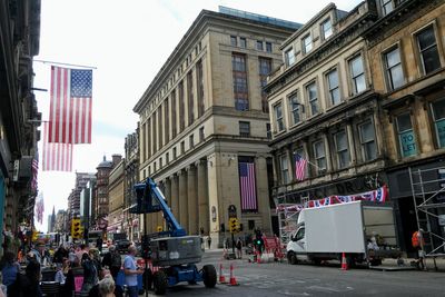 People on street amidst buildings in city