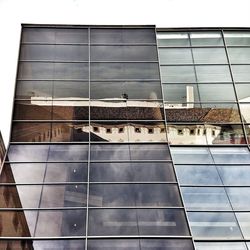 Low angle view of glass building against sky