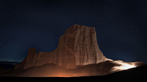 Low angle view of rock formation against sky at night