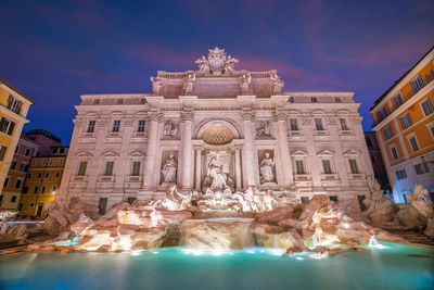 Low angle view of fountain in city against sky