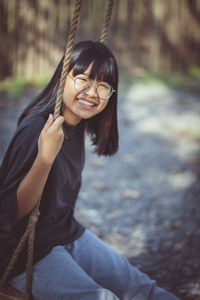 Toothy smiling face of asian teenager relaxing in public park