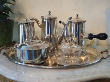 Close-up of antique silver dishes on marble table