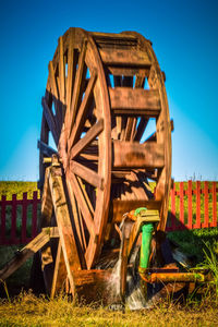 View of wood water wheel against clear blue sky